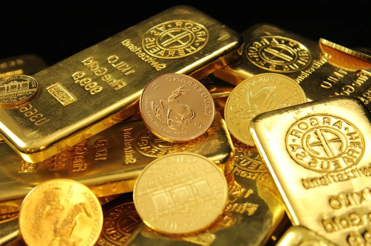 Fotografija zlatnih poluga i kovanica različitih marki, uključujući Argor Heraeus i Krugerrand.