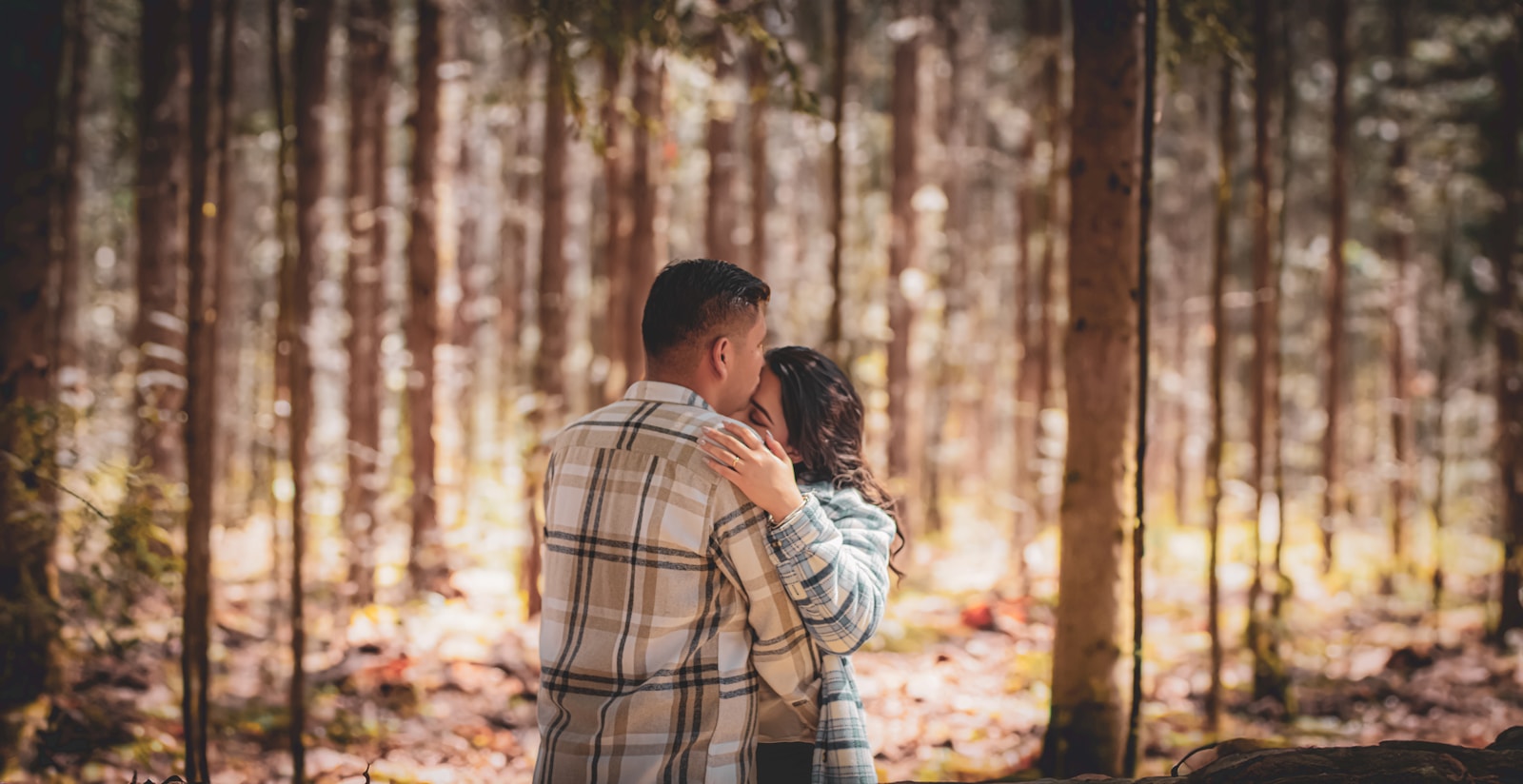a man and woman embracing in the woods