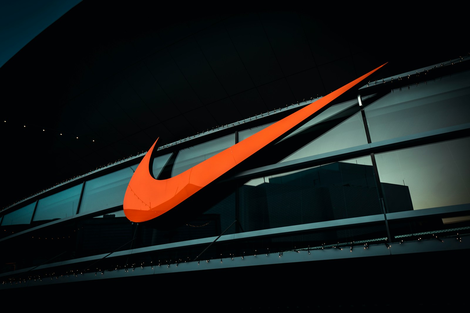 a large orange nike logo on the side of a building