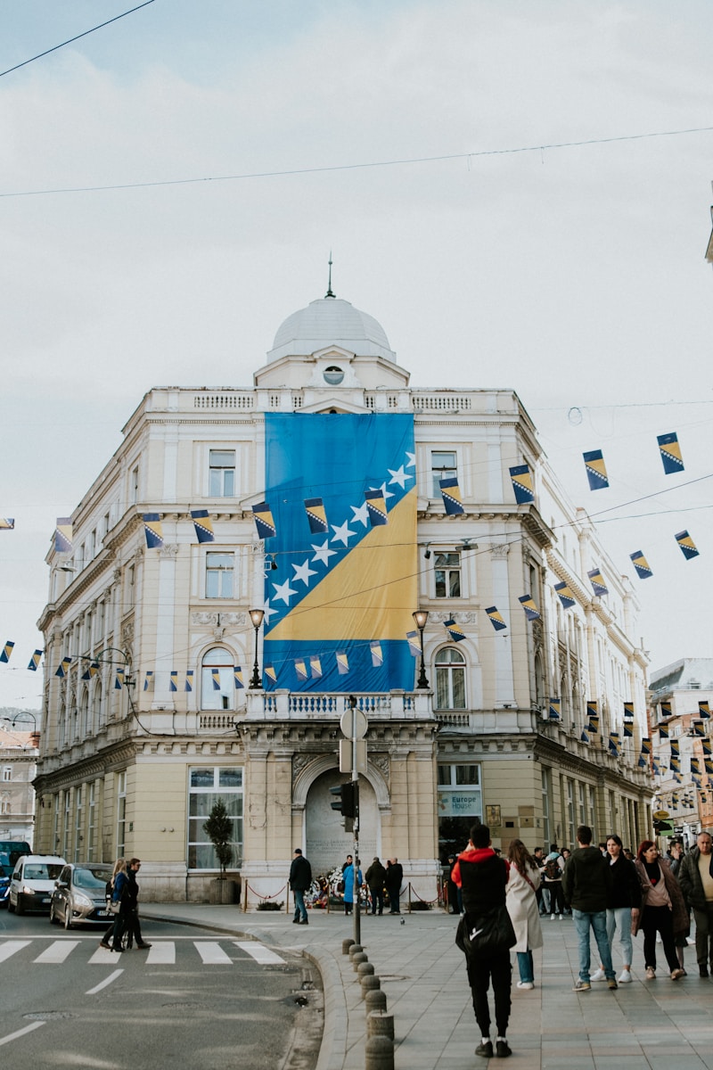a group of people walking down a street next to a tall building
