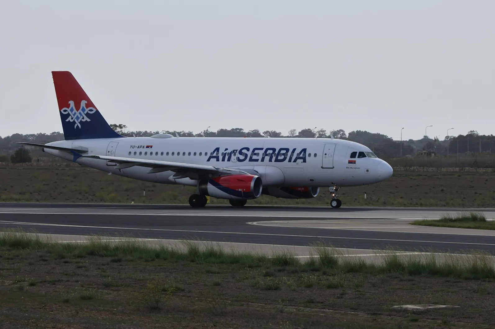 An Air Serbia airplane taxiing on a tarmac.