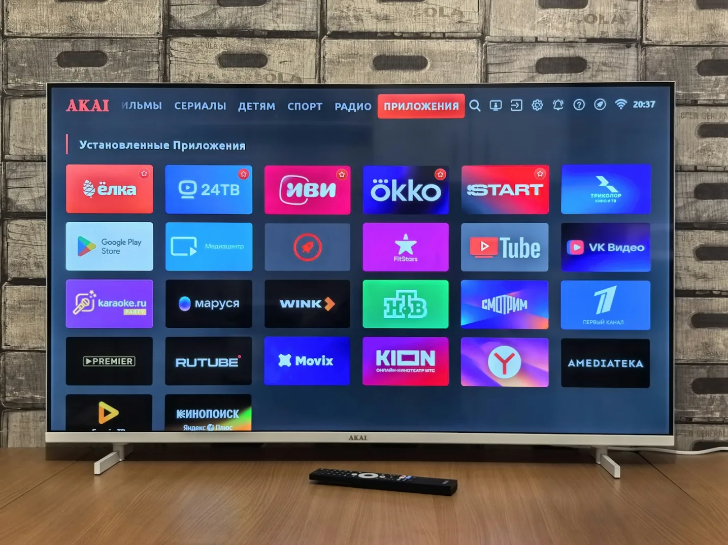 Akai Smart TV interfejs prikazuje ekran sa instaliranim aplikacijama, uključujući Google Play Store, YouTube, VK Video, Kinopoisk, Rutube i druge.