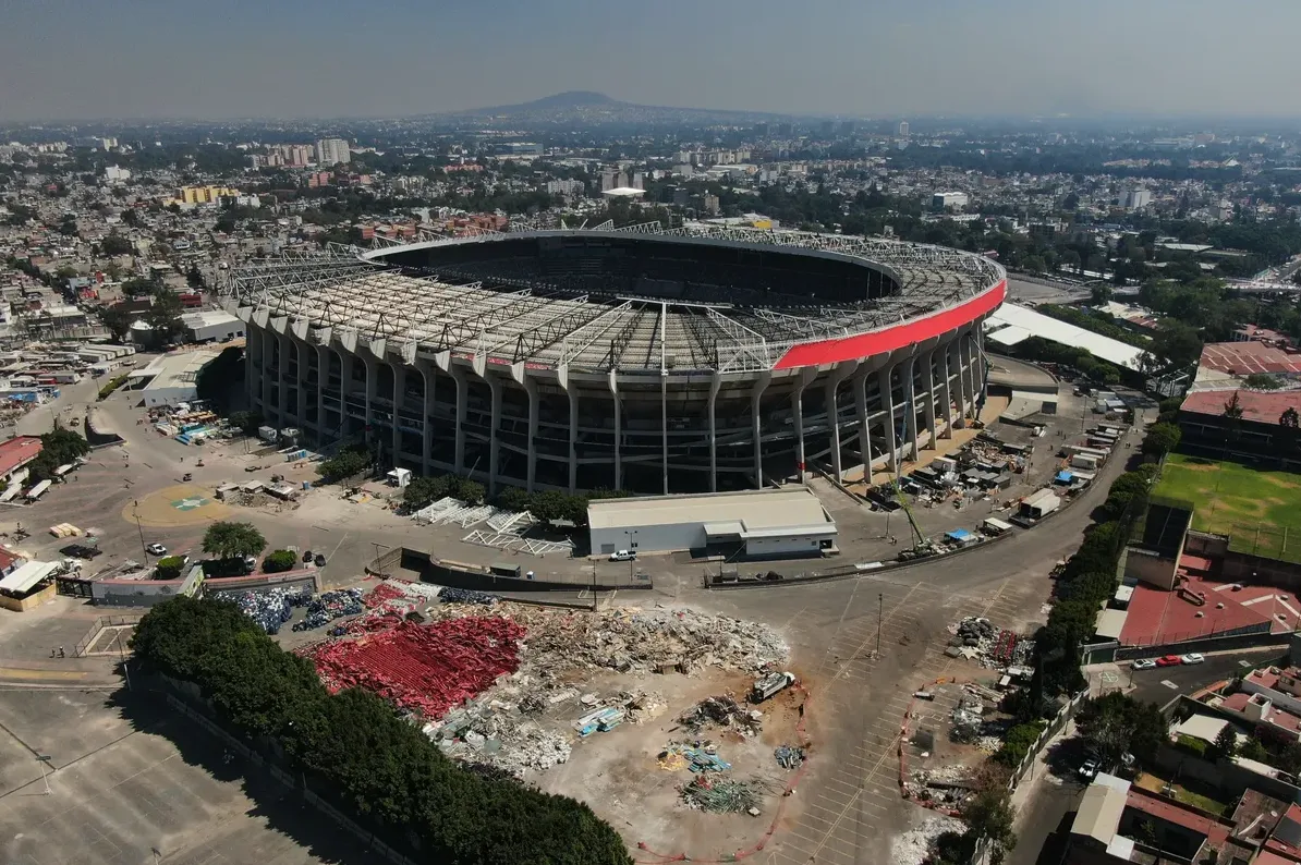 Azteca stadion, jedan od najpoznatijih stadiona na svijetu, snimljen iz zraka, prikazuje njegovu impresivnu arhitekturu i okolinu sa urbanim pejzažom i zelenilom u pozadini.