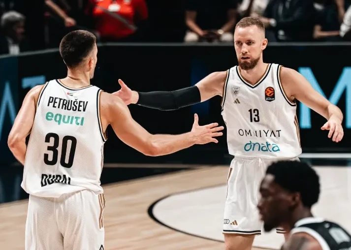 Dva košarkaša se visoko rukuju tokom utakmice.