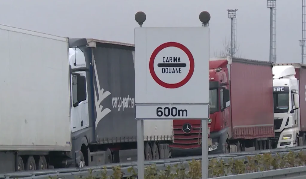 Saobraćajni znak "Carina Douane" sa oznakom udaljenosti od 600 metara, ispred kolone kamiona na graničnom prelazu.