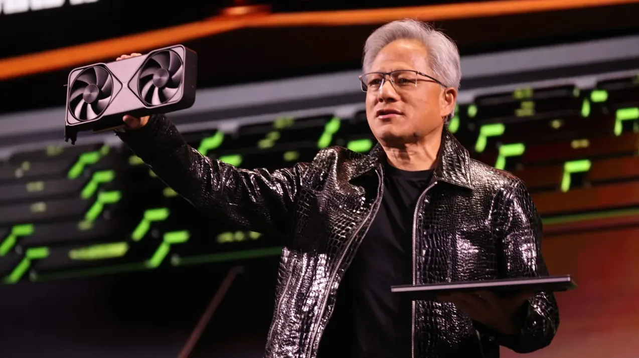 Jensen Huang, izvršni direktor Nvidije, pokazuje novu grafičku karticu dok drži laptop u drugoj ruci.