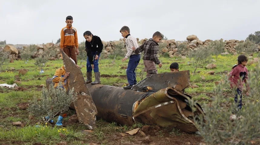 Djeca se igraju oko ostataka velike rakete u polju