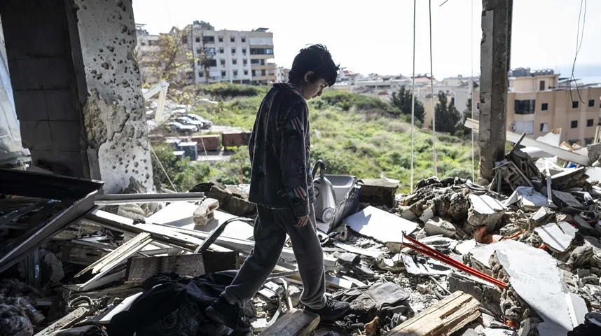 Dječak hoda kroz ruševine zgrade.