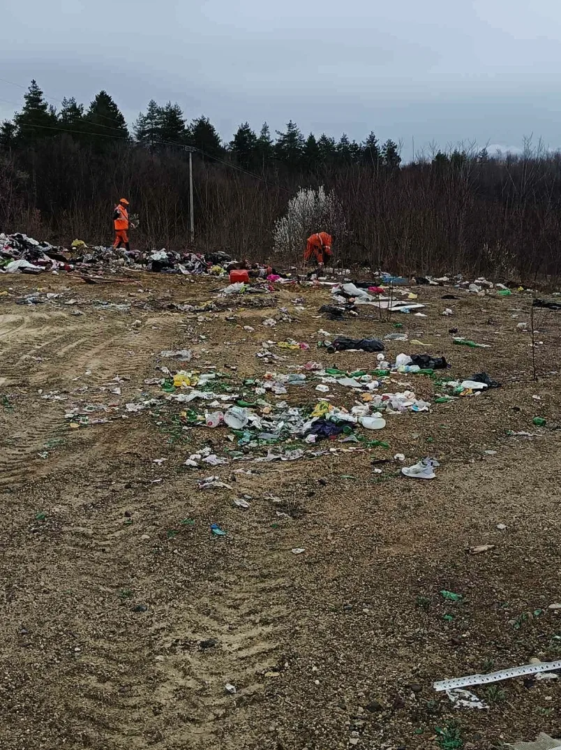 Dva radnika u narandžastim kombinezonima čiste divlje deponije