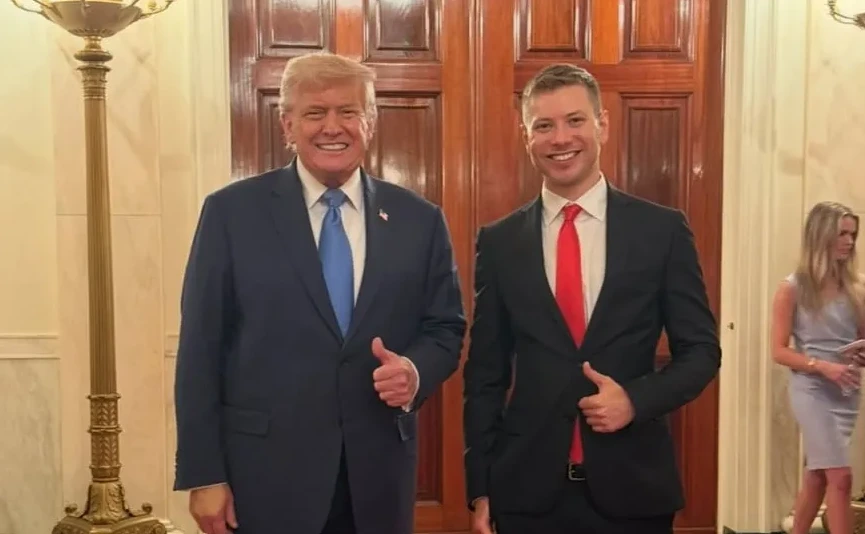 Donald Trump i mladi muškarac sa podignutim palčevima, oboje u odijelima.