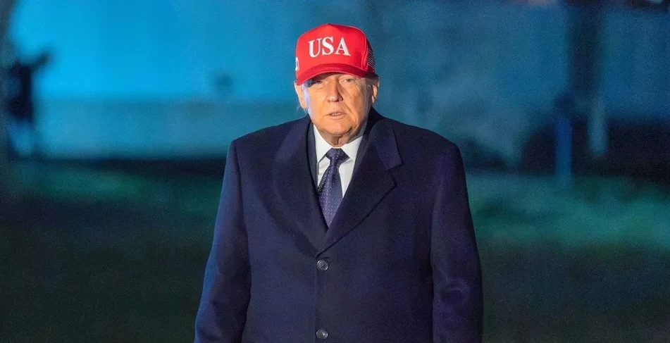 Donald Trump u crvenoj kapi s natpisom "USA" i tamnoplavom kaputu