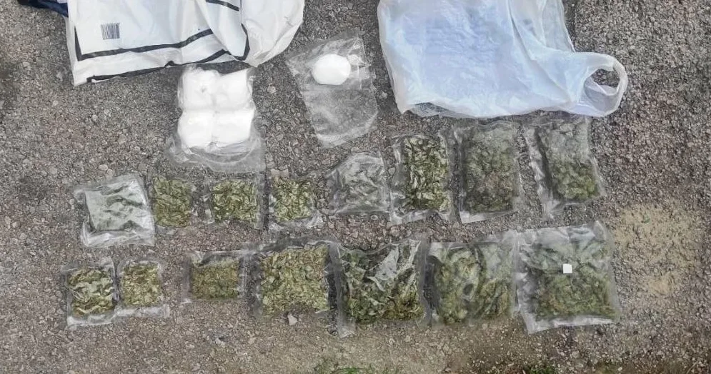 Više paketića droge i bijele materije raspoređeno na šljunku.