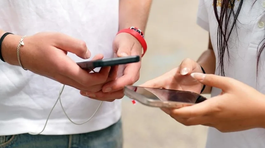 Dvoje mladih ljudi, dječak i djevojčica, koriste pametne telefone