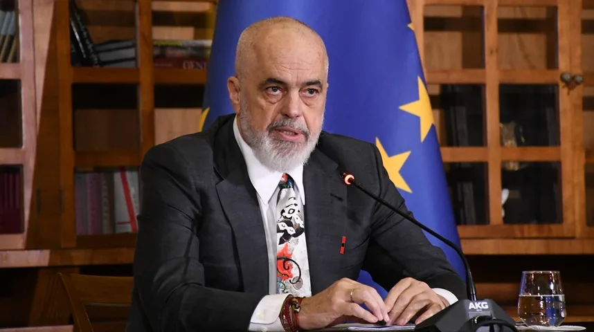 Edi Rama, premijer Albanije, sjedi za stolom s mikrofonom i čašom vode ispred zastave Evropske unije.