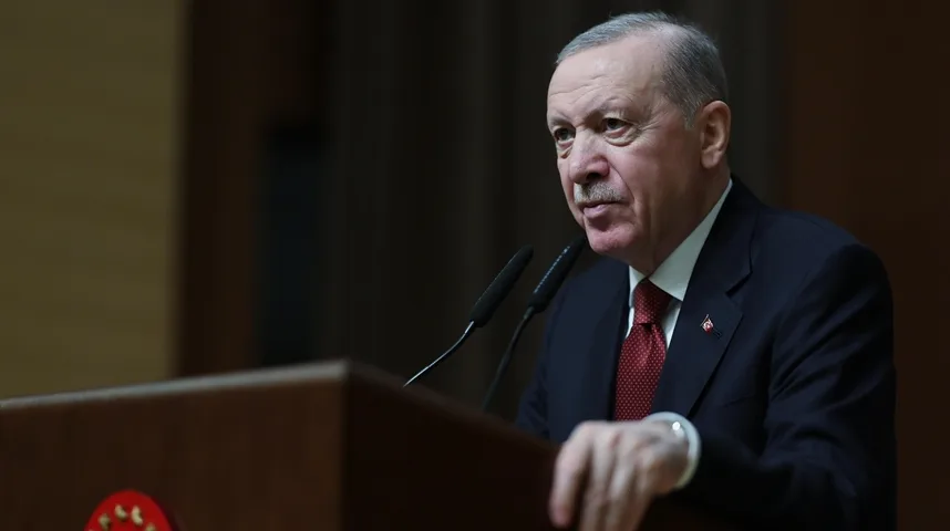 Turski predsjednik Recep Tayyip Erdoğan govori iza govorničkog podijuma sa dva mikrofona ispred njega.