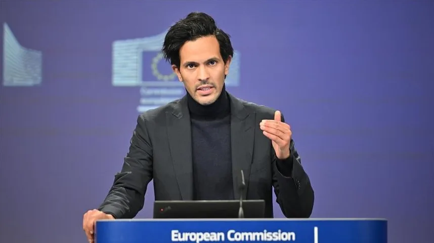 Političar u tamnom odijelu i rolci govori pred plavom pozadinom sa logom Evropske komisije