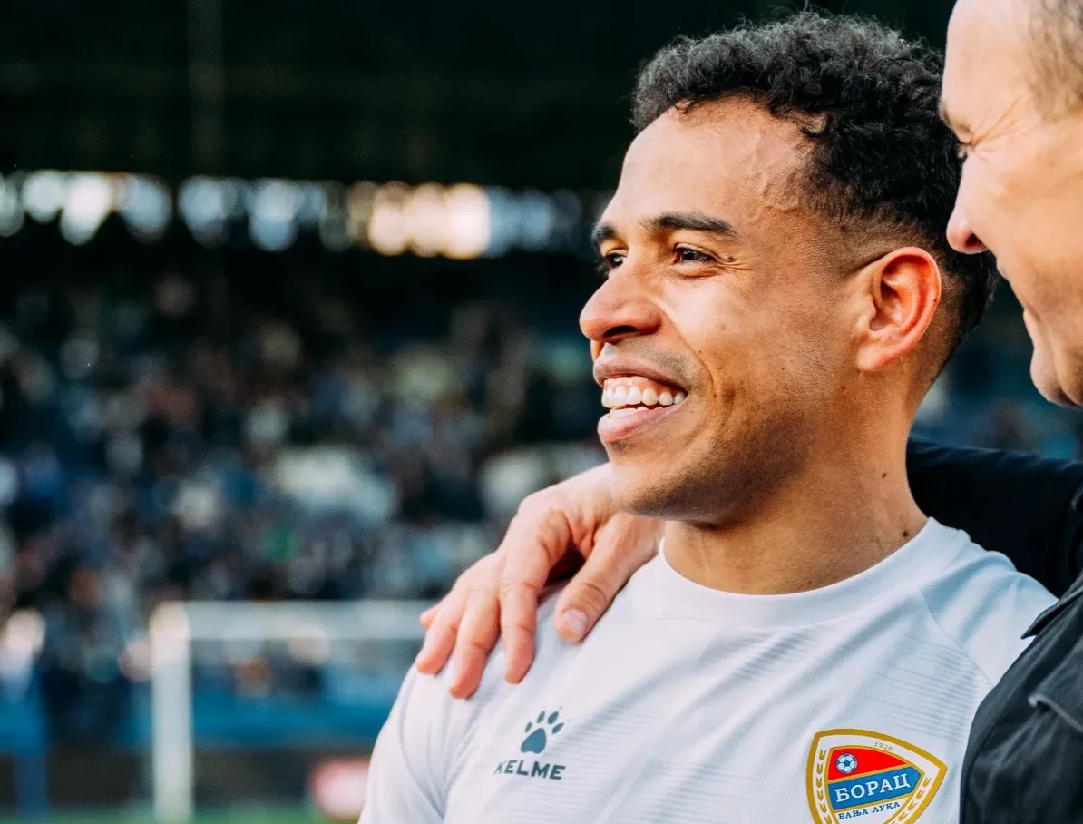 Fudbaler FK Borac sa kapitenom ili trenerom, nasmijan, na stadionu