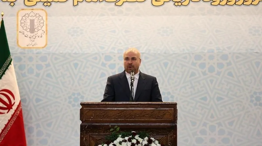 Muškarac u tamnom odijelu i bijeloj košulji govori za govornicom.