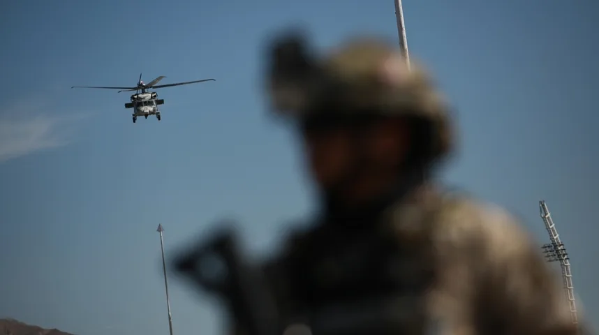 Helikopter vojne mornarice leti iznad vojnika u maskirnoj uniformi.