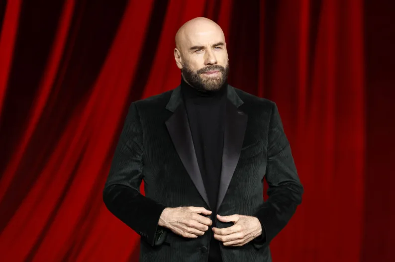 Džon Travolta u crnom sakou sa crnim rolkom