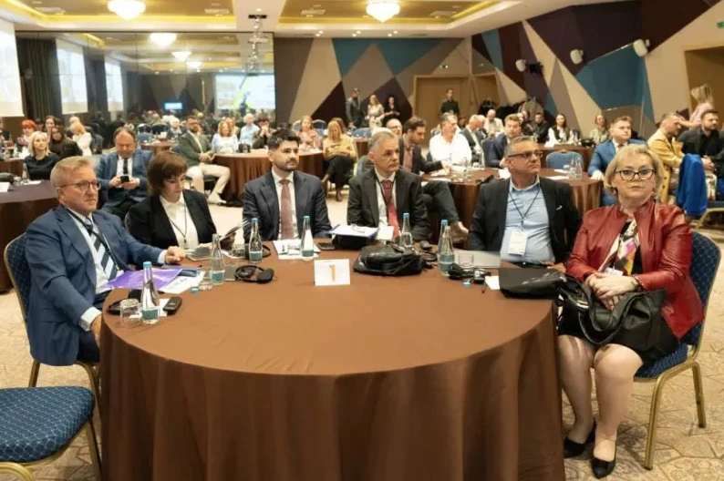 Grupa poslovnih ljudi sjedi za okruglim stolom na konferenciji.