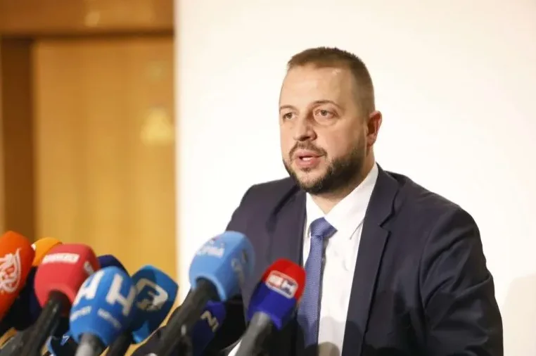 Ministar drži govor ispred grupe mikrofona