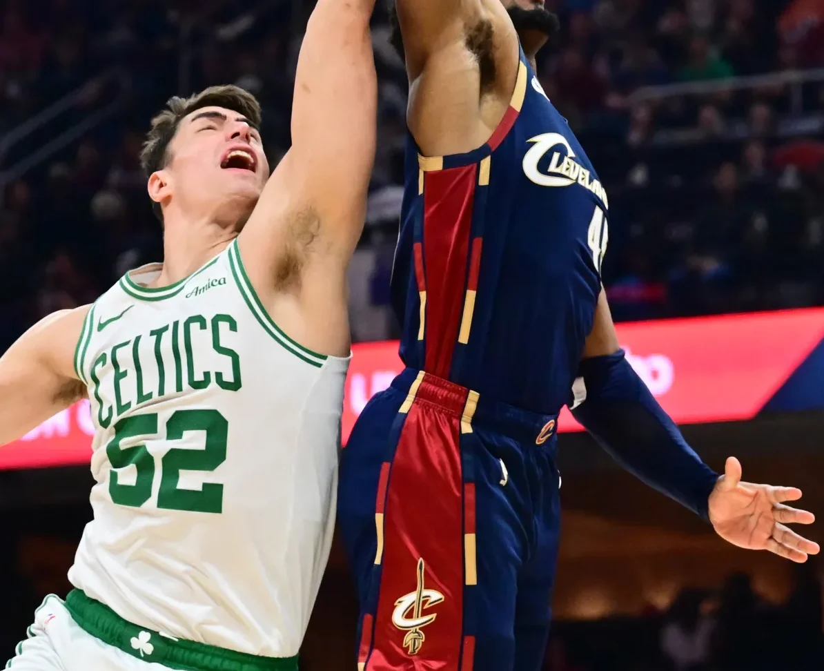Košarkaš Boston Celticsa sa brojem 52 na dresu u bijeloj boji sa zelenim detaljima i natpisom 'CELTICS' te košarkaš Cleveland Cavaliersa u tamnoplavom dresu sa crvenim i zlatnim detaljima tokom utakmice.