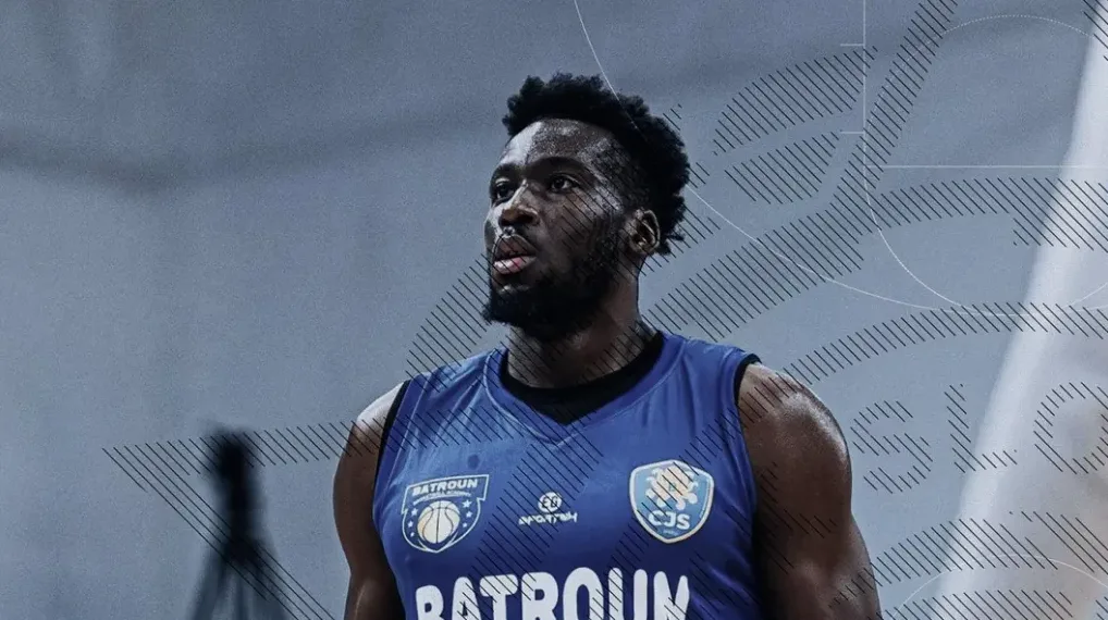 Crni košarkaš u plavom dresu gleda prema gore.