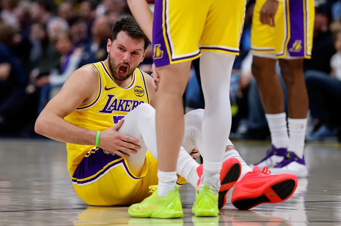 Košarkaš Los Angeles Lakersa sjedi na parketu sa izrazom bola na licu, držeći se za nogu.