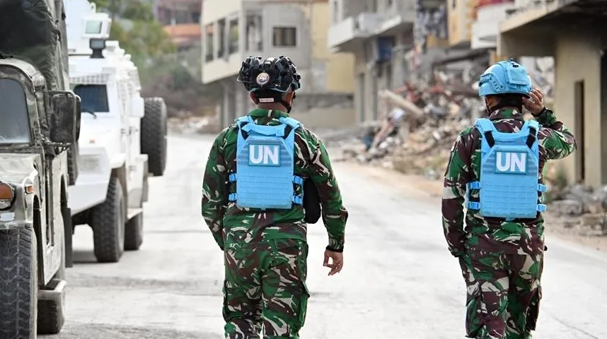 Pripadnici misije Ujedinjenih nacija (UN) u uniformama i sa zaštitnim prslucima sa oznakom UN hodaju ulicom