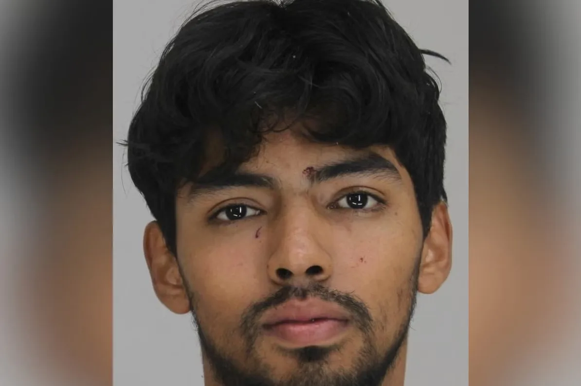 Portret mladića sa kratkom, tamnom, valovitom kosom i urednom bradom. Na čelu mu je vidljiva mala povreda ili ogrebotina. Oči su mu tamne, a lice djeluje smireno.