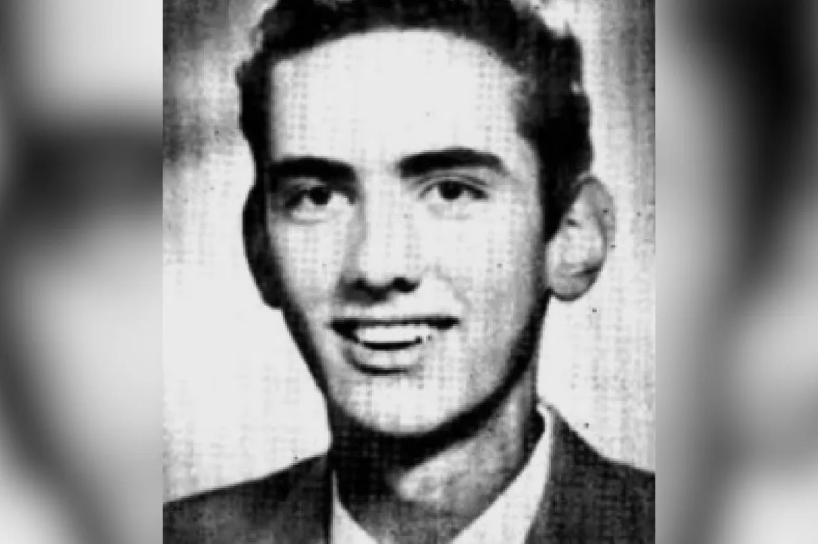 Portret mladog muškarca sa tamnom kosom i osmijehom, nosi odijelo