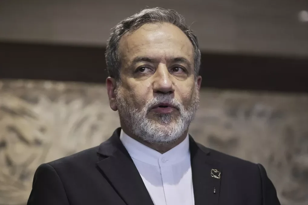 Portret muškarca sa sijedom bradom i kosom, obučenog u crno odijelo i bijelu košulju.