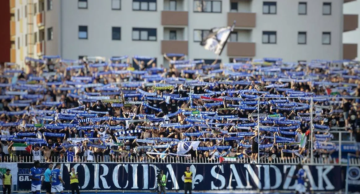 Veliki broj navijača FK Novi Pazar na stadionu, drže plave šalove i transparente.
