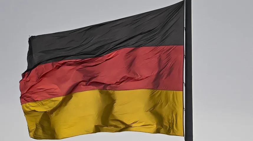 Njemačka trobojnica na zastavnom stubu, sa crnom, crvenom i žutom horizontalnom prugom, koja se vijori na vjetru.