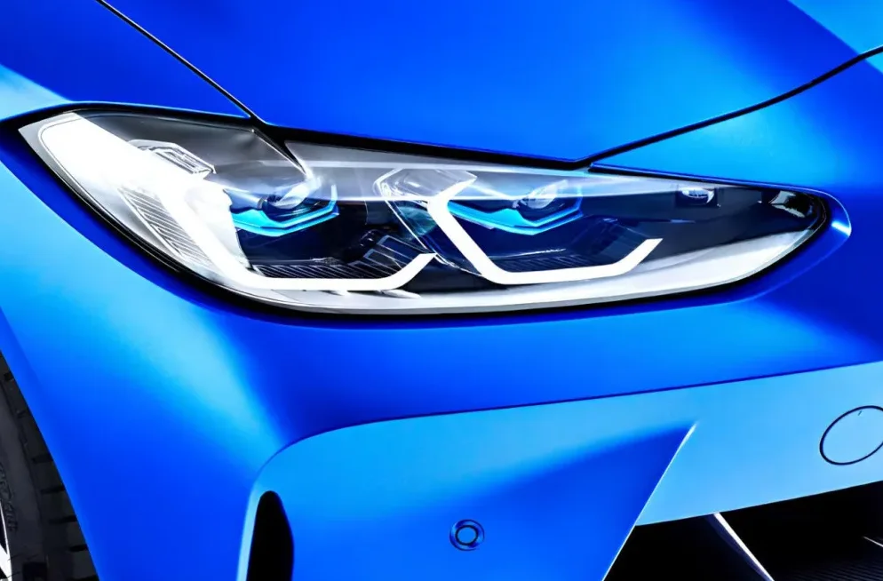 Detaljan prikaz modernog prednjeg fara plavog automobila.