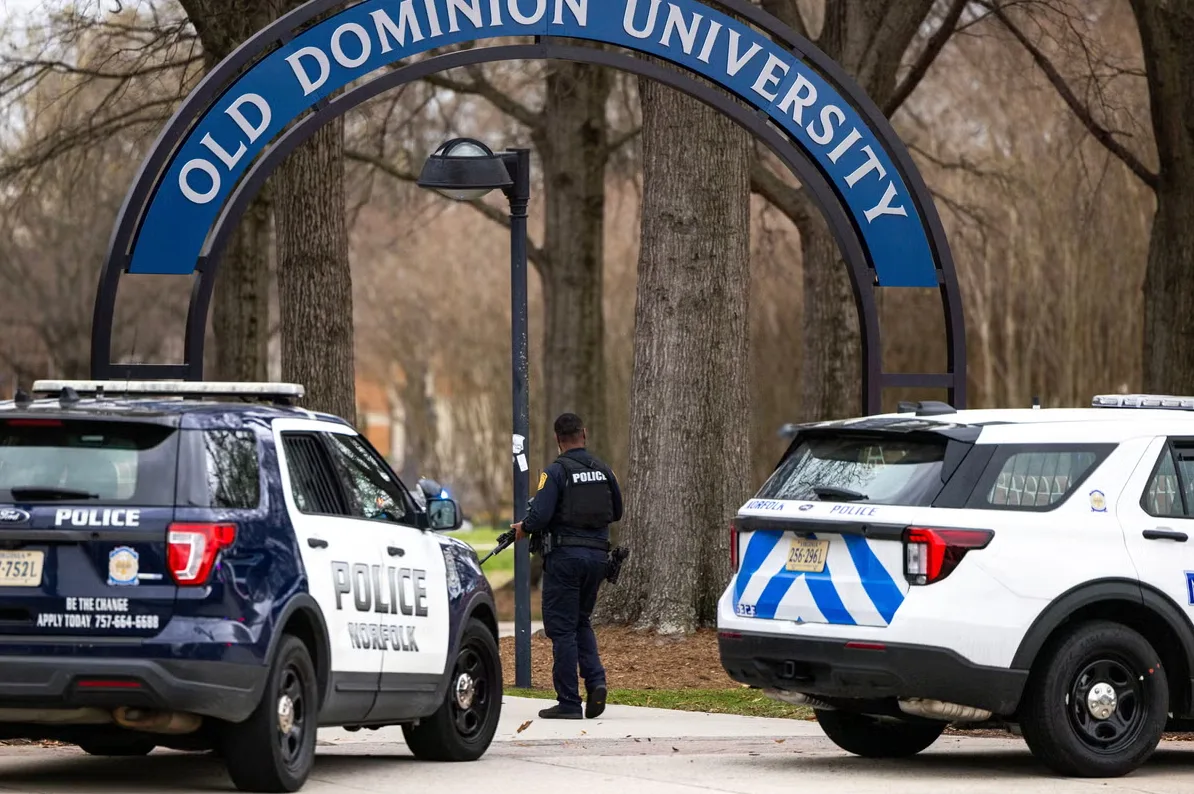 Policajac u uniformi stoji pored policijskih automobila na Old Dominion University.