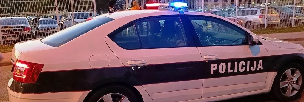 Policijsko vozilo sa upaljenim plavim rotacionim svjetlima u mraku.