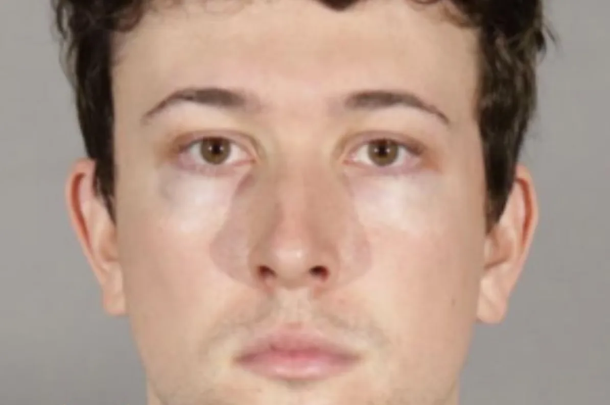 Portret mladog muškarca sa smeđim očima i tamnom kosom.