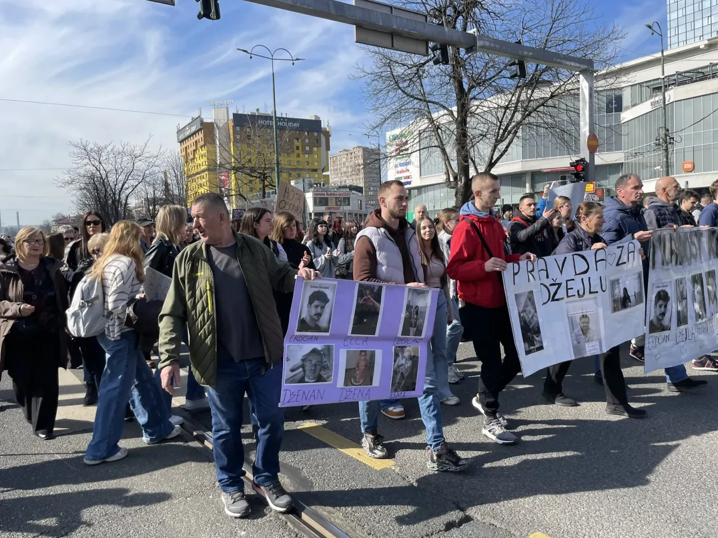 Građani na ulici drže transparente sa slikama poginulih osoba, uz natpis "Pravda za Džidžu".