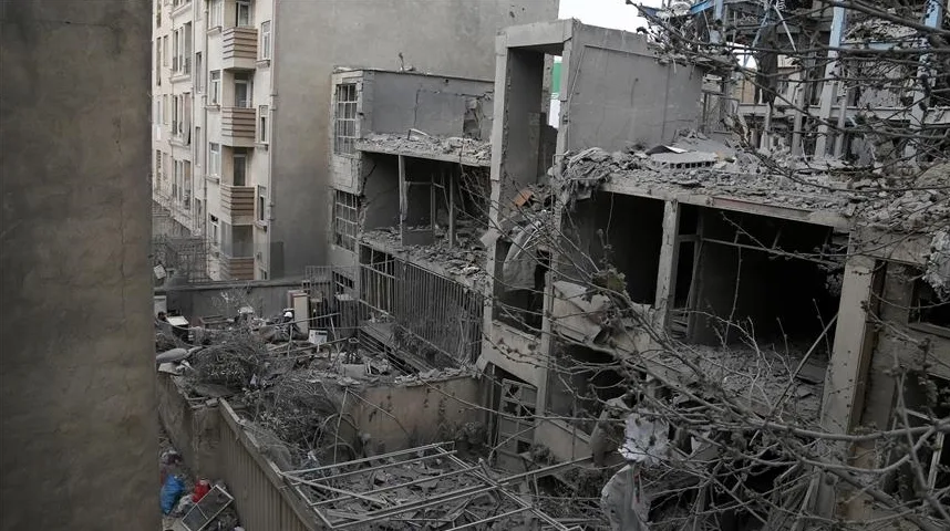 Prizor uništenih zgrada nakon sukoba, sa oštećenim fasadama, polupanim prozorima i krhotinama construction materijala na sve strane.