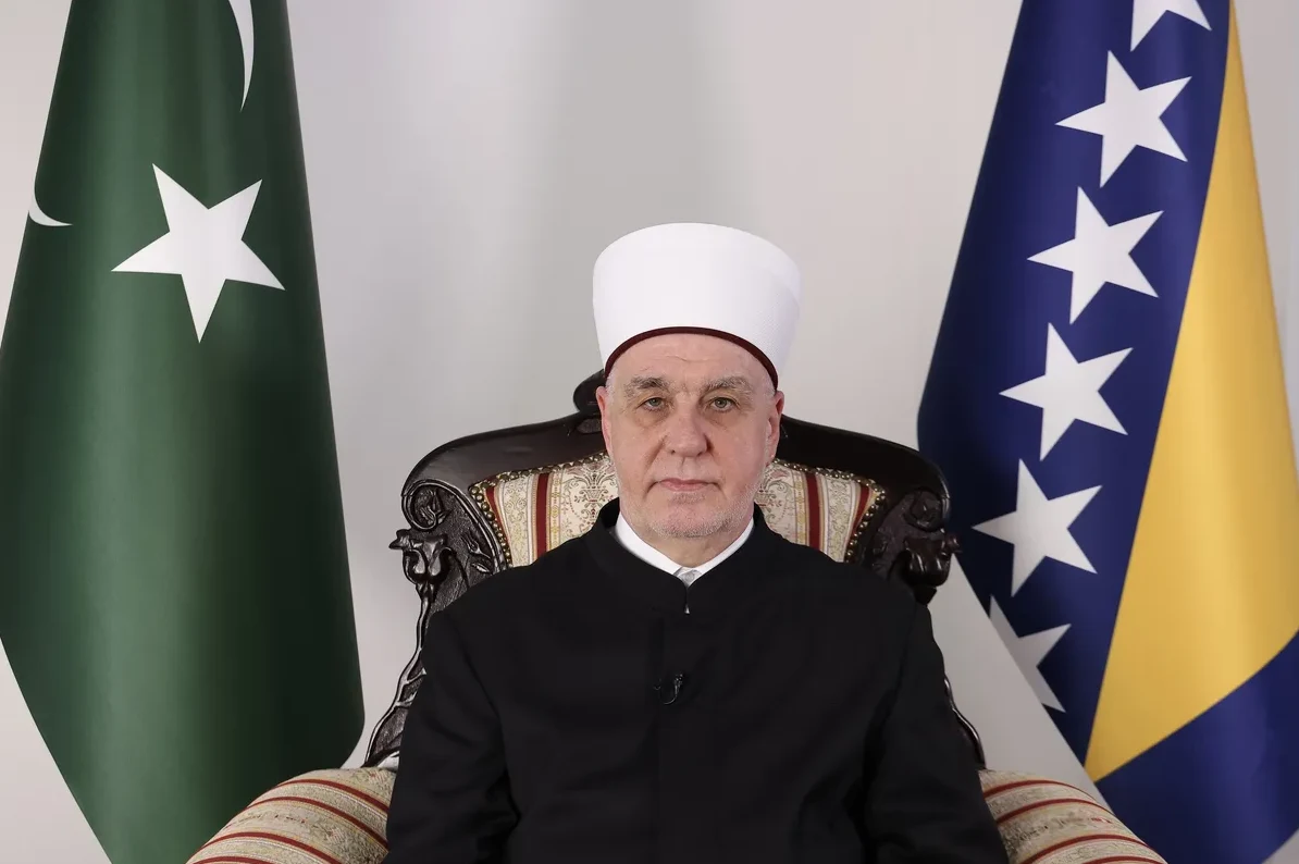 Reis-ul-ulema Husein ef. Kavazović sjedi između zastava Bosne i Hercegovine i Pakistana.