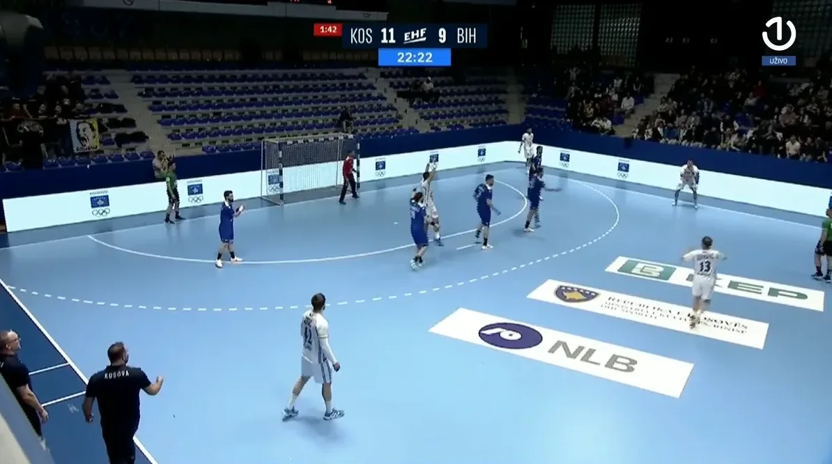 Rukometni teren s igračima u plavim i bijelim dresovima, rezultat KOS 11 - BIH 9.