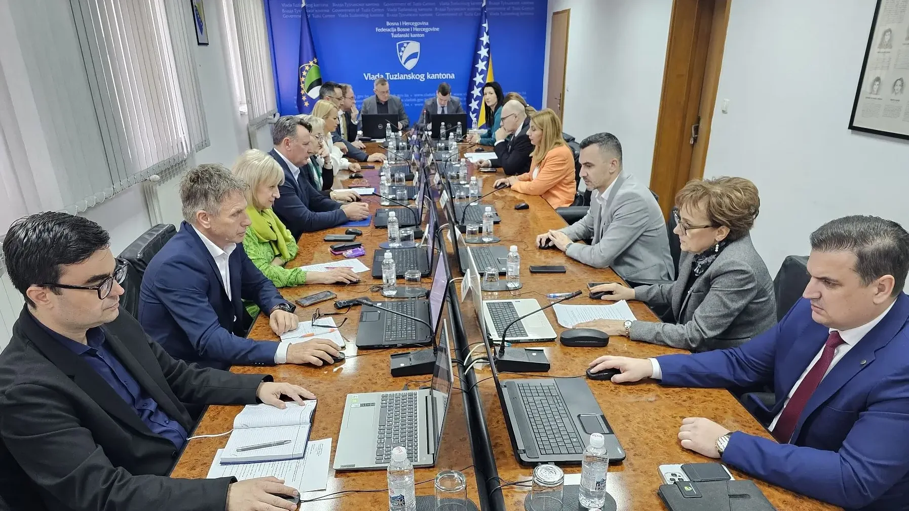Grupa zvaničnika sjedi za dugim stolom tokom sastanka Vlade Tuzlanskog kantona.