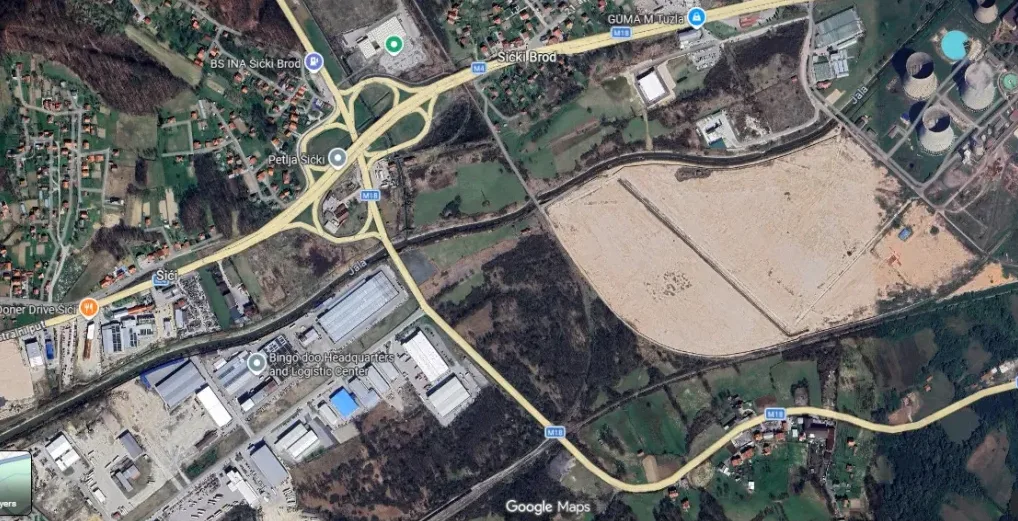 Satelitski prikaz saobraćajnice M18 u blizini Šičkog Broda, sa industrijskim zonama i rashladnim tornjevima.