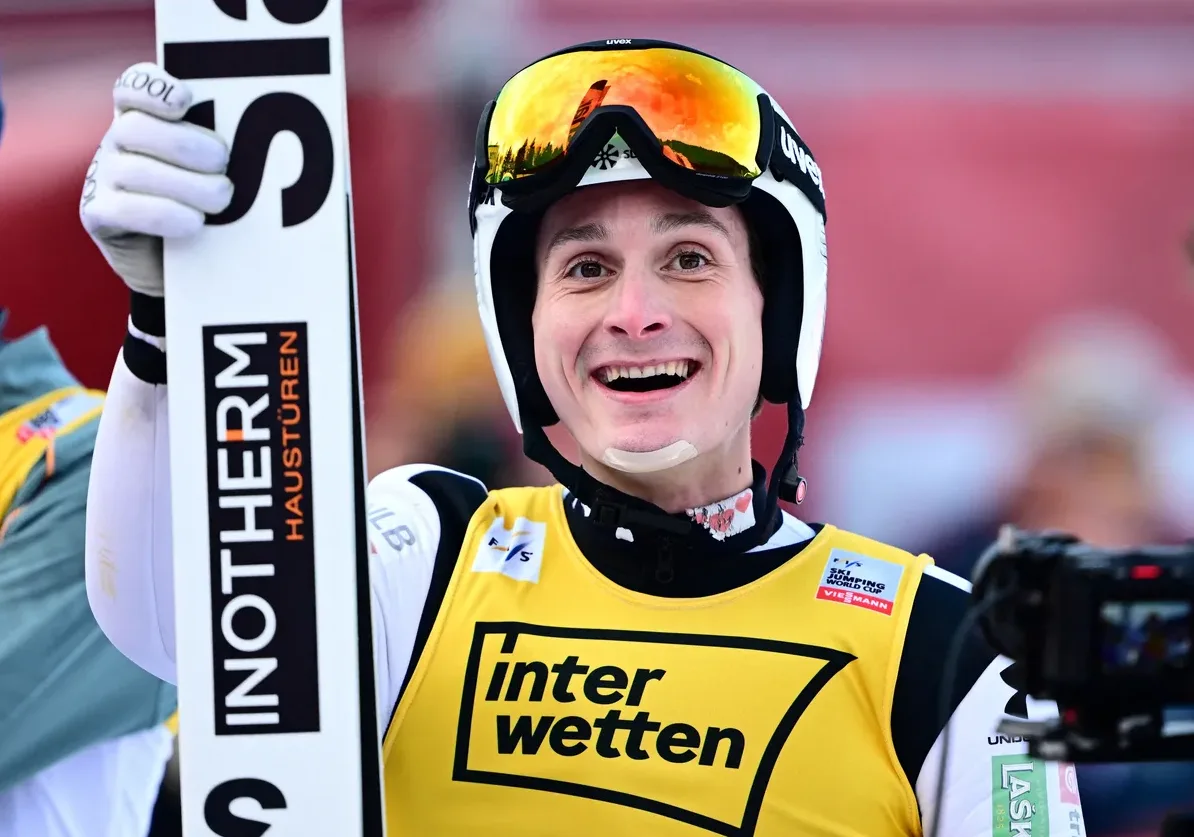 Skijaš sa skijama i kacigom se smije