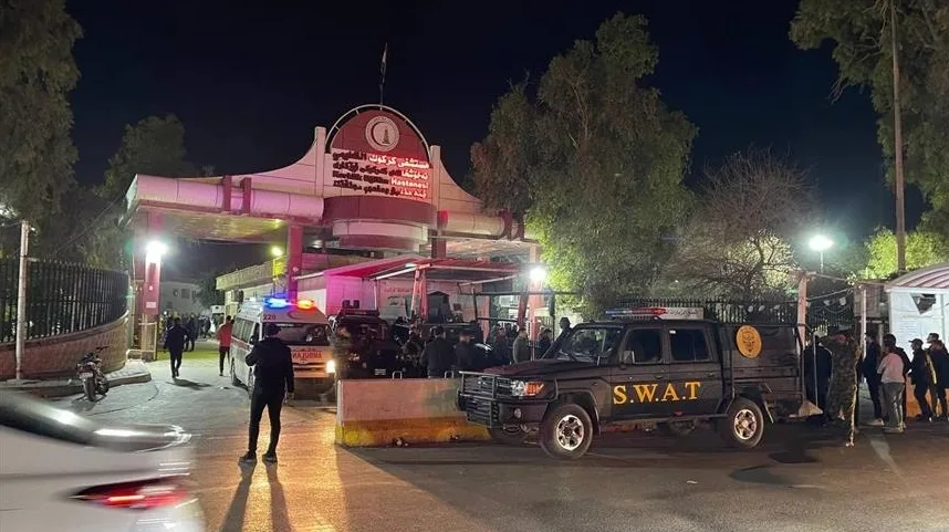 Specijalno vozilo sa oznakom S.W.A.T. parkirano ispred ulaza u bolnicu noću, sa upaljenim rotirajućim svjetlima na policijskim vozilima i prisustvom nekoliko osoba.