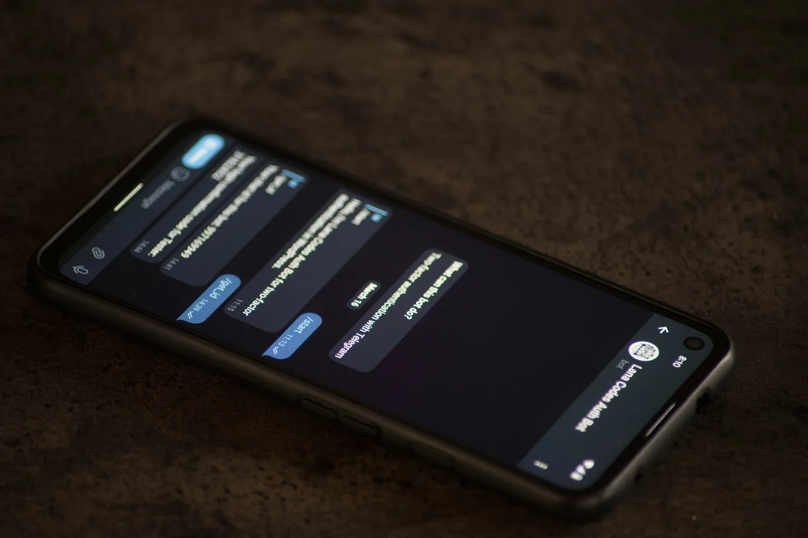 Telefon koji prikazuje Telegram chat sa "Lana Codes Auth Bot" gdje korisnik postavlja pitanje "Šta ovaj bot može raditi?" i prima odgovor vezan za dvofaktorsku autentifikaciju.