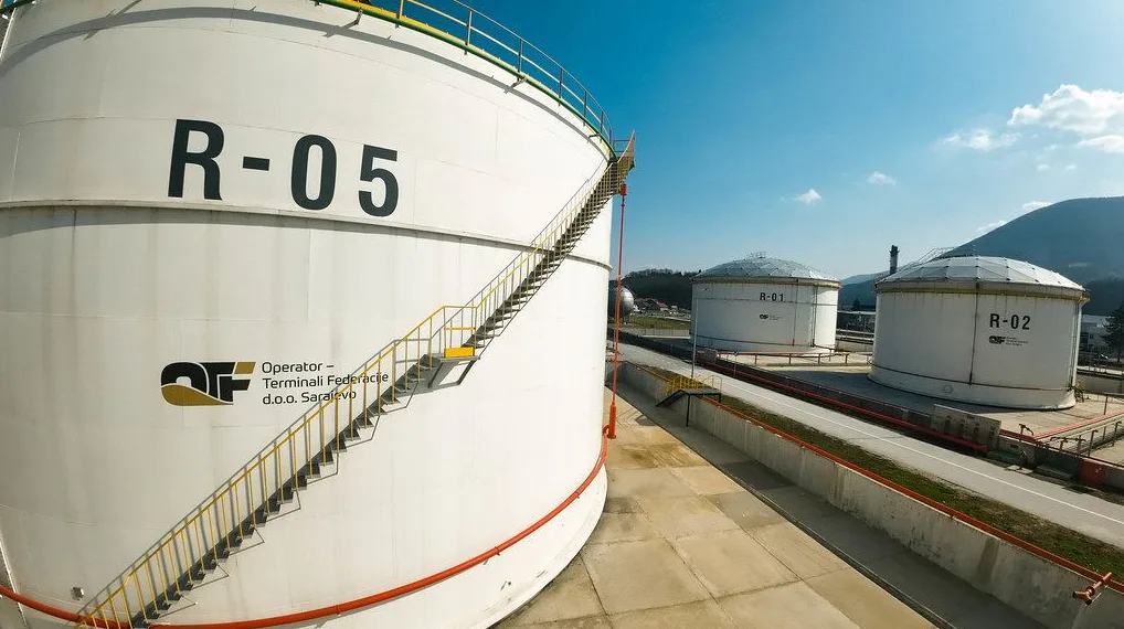 Veliki industrijski rezervoar sa oznakom R-05 i stepeništem, te drugim rezervoarima u pozadini R-01 i R-02.