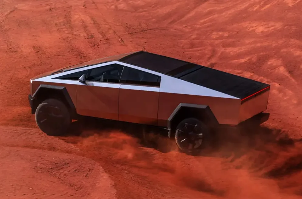 Tesla Cybertruck se kreće kroz crveni prah u pustinji.